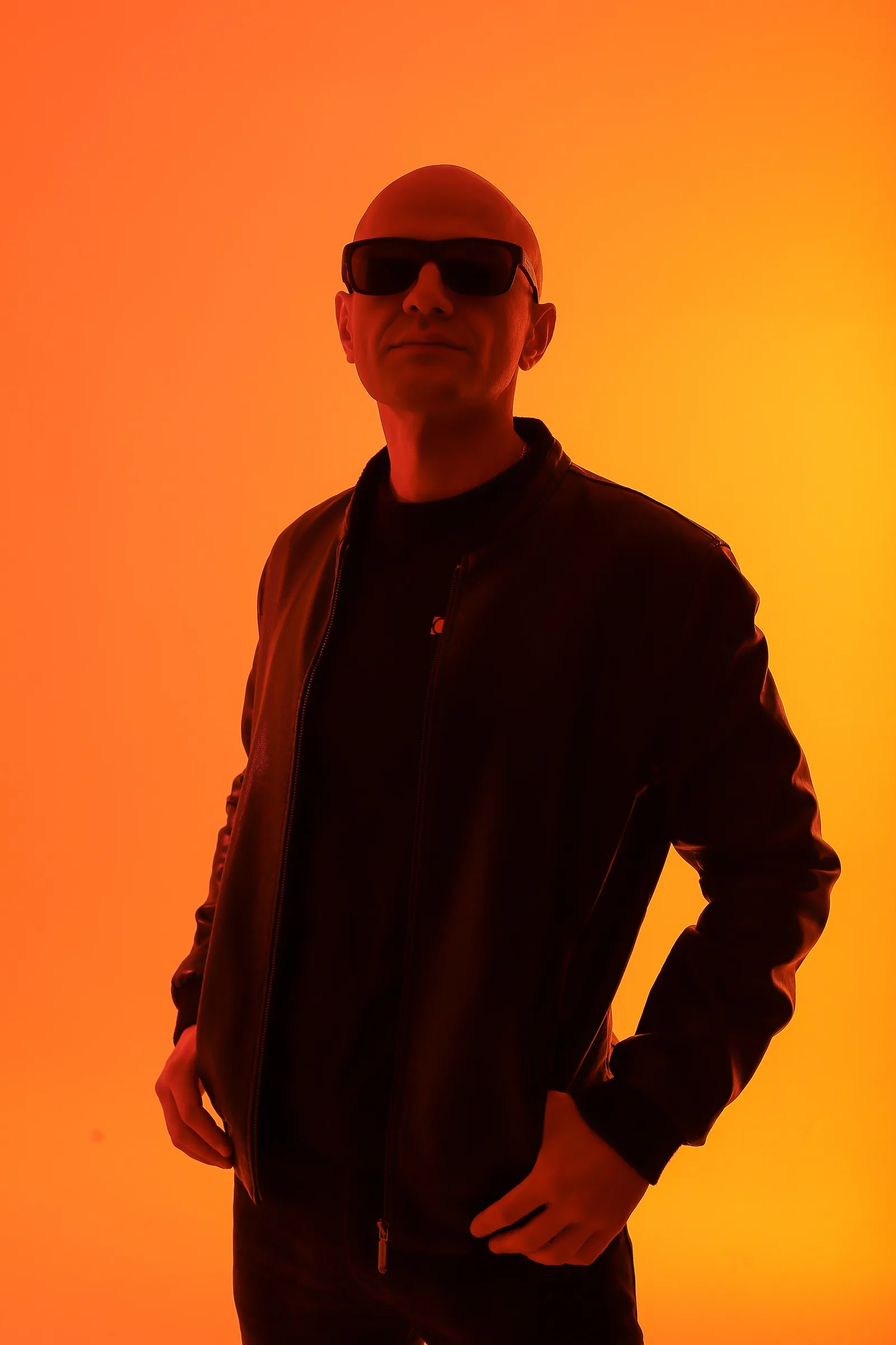 GANGSTANTIN facing the camera against an orange-lit background.