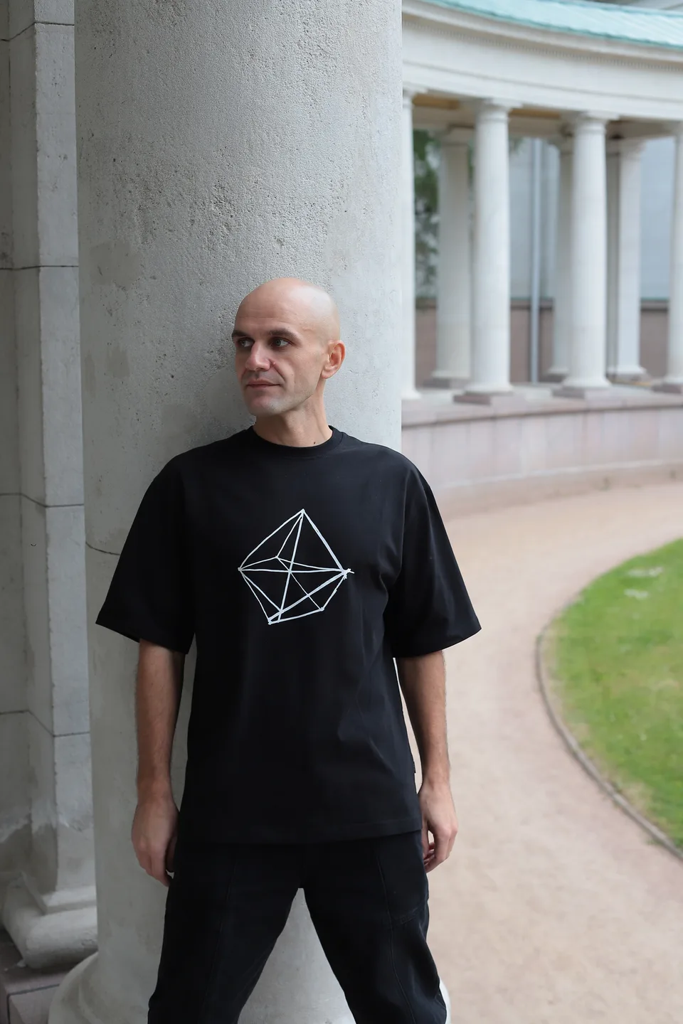 GANGSTANTIN standing beside a white colonnade.