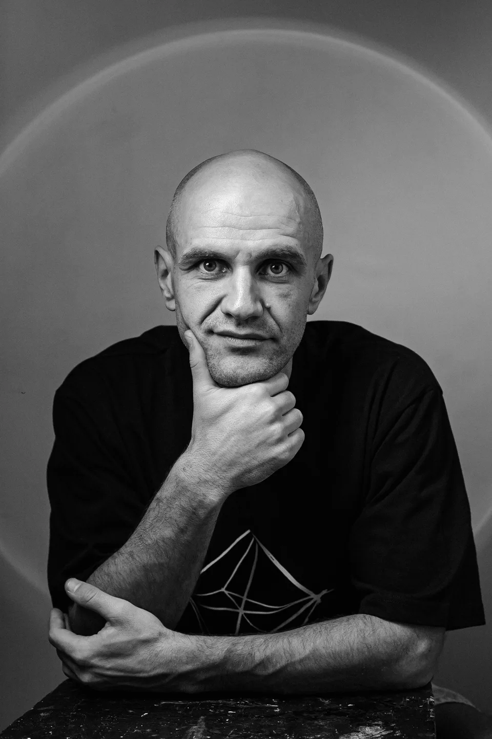 Monochrome portrait of GANGSTANTIN resting his chin on one hand.